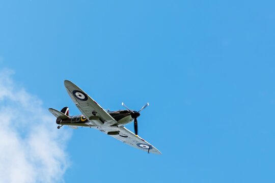 Cambridge, United Kingdom - September 12 2015 - A Supermarine Spitfire World War 2 figher plane flies over the skies of Cambridge during the Dragon Boat Festival