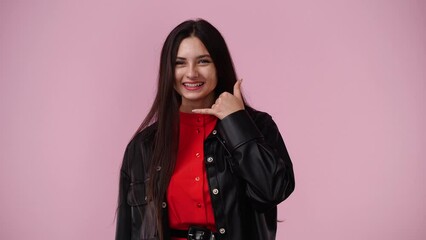 4k video of girl making telephone gesture near head call me sign on pink background.