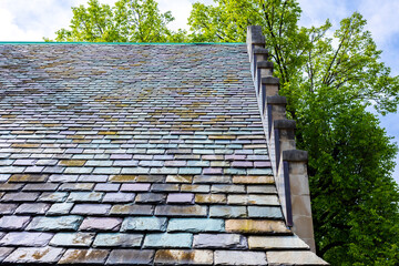 An ornate peaked slate roof in blue, purple, and brown.