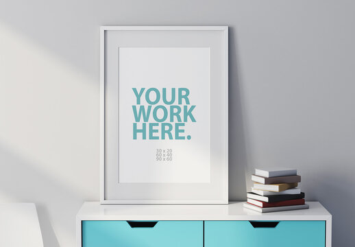 White Poster Art Frame Mockup with passepartout on commode with books