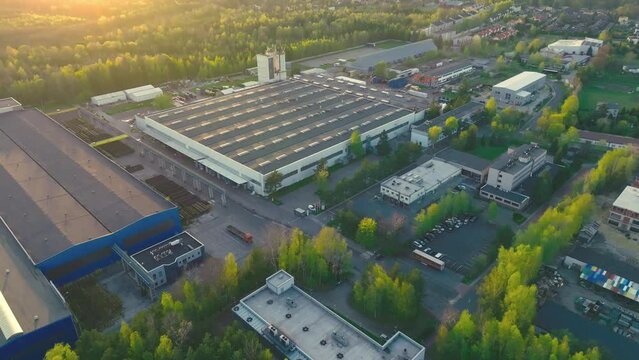 An industrial giant glows in the warmth of the setting sun. The aerial shot captures the magnitude of the building, surrounded by smaller structures.