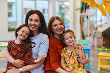 A child hugging a teacher in a modern kindergarten