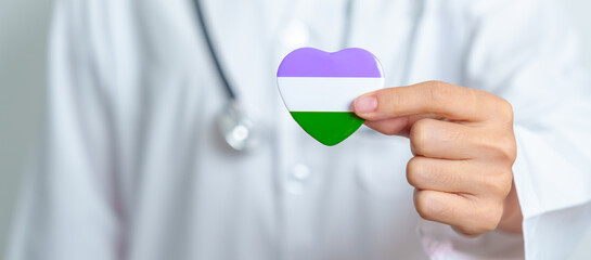 Queer Pride Day and LGBT pride month concept. Doctor hand holding purple, white and green heart...
