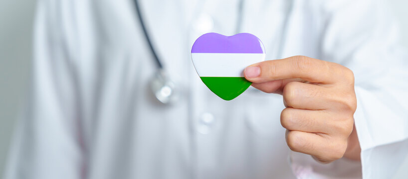 Queer Pride Day and LGBT pride month concept. Doctor hand holding purple, white and green heart shape with Stethoscope for Lesbian, Gay, Bisexual, Transgender, genderqueer and Pansexual community