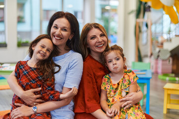 A child hugging a teacher in a modern kindergarten