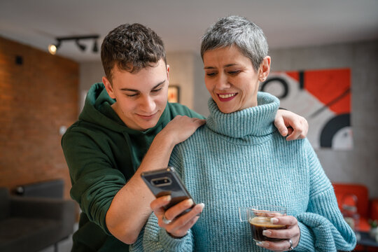 teenager boy young man and mature woman mother and son take selfie photos self portraits at home - Powered by Adobe