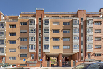 Front facade of urban residential buildings with access to garages and aluminum