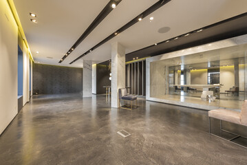 An empty retail space with polished concrete floors and ceiling lighting fixtures