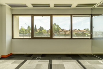 empty offices with separate offices with glass partitions, large windows with unobstructed views of other buildings