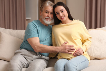 Father and his pregnant daughter indoors. Grandparents' reaction to future grandson