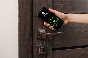 Woman unlocking door using mobile phone, closeup. Illustration of closed and open padlocks on device screen
