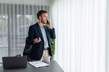 Hardworking businessman stand confidently in modern office making persuasive sales call to client....