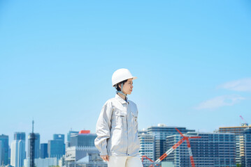 ヘルメットを装着して作業着を着た女性