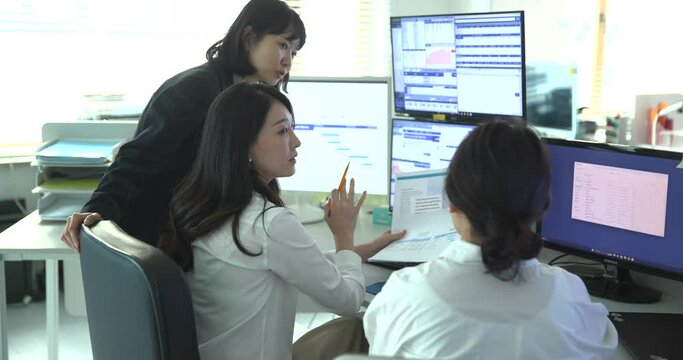 모니터를 함께 보며 회의하는 동료들 