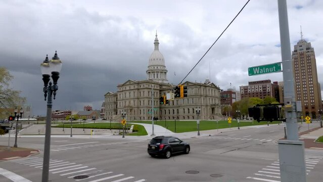Michigan State Capitol building in Lansing, Michigan with drone video pulling back low.