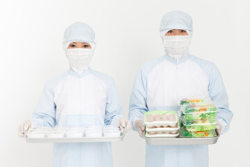 食品を持つ防護服姿の男女
