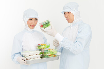 食品を持つ防護服姿の男女