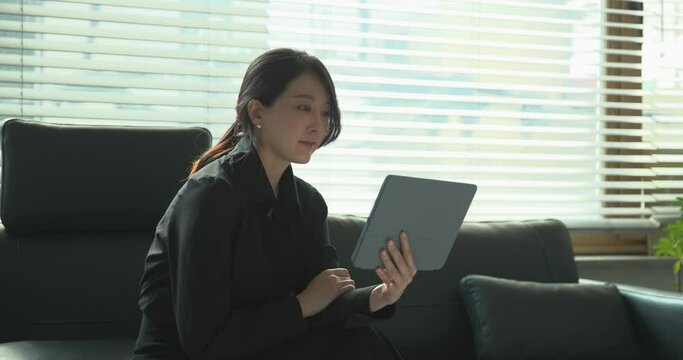 소파에 앉아 태블릿을 보고있는 여성 리더