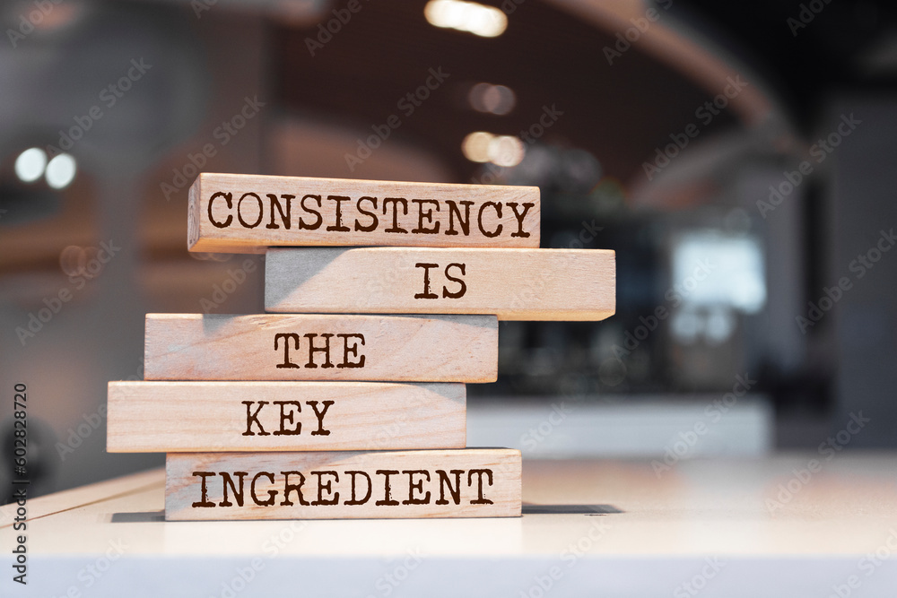 Wall mural Wooden blocks with words 'Consistency is the key ingredient'.