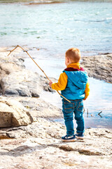 Little boy fishing in a river (back view)