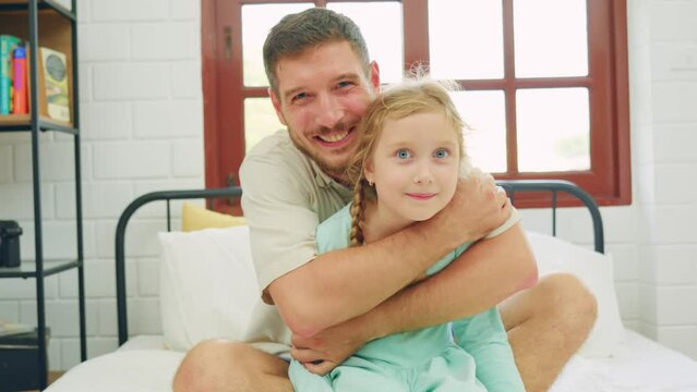 Caucasian father spend leisure time with baby gir in bedroom at house.