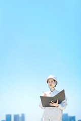 現場を確認する作業着姿の女性