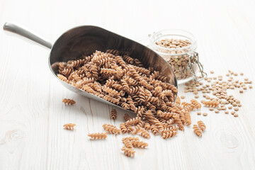 Green lentil fusilli pasta on a wooden background.