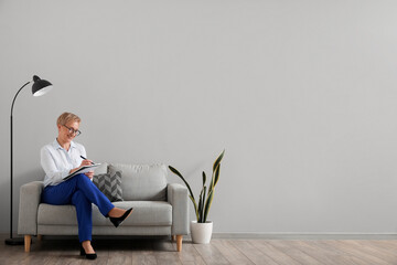 Mature psychologist working with notebook in office