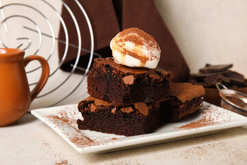 Plate with pieces of tasty chocolate brownie and ice cream on light background