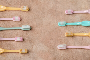 Different plastic toothbrushes on color background