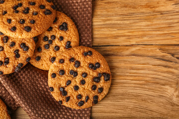 Tasty cookies with chocolate chips on wooden background