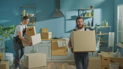 Workers of Moving Company With Uniforms Carefully Carrying Boxes. Team of Employee Workers Helps Customers to Relocation. Local Moving Services
