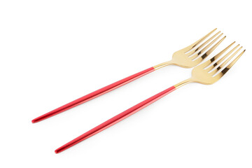 Golden forks with red handles on white background