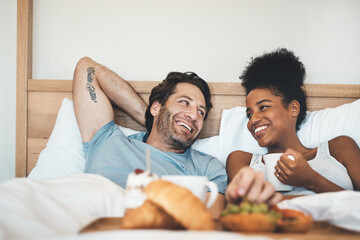 Happy interracial couple, bed and breakfast in relax for morning, bonding or relationship at home....