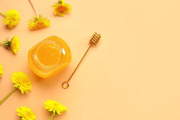 Jar with dandelion honey on orange background