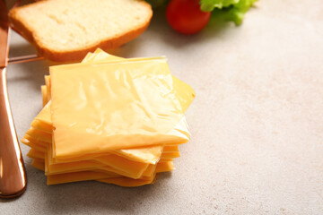 Slices of tasty processed cheese on light background