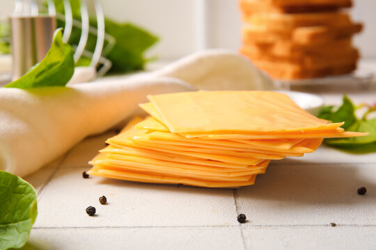 Slices of tasty processed cheese on table