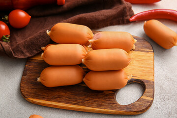 Board of tasty boiled sausages on grey background
