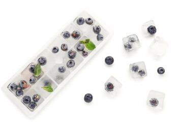 Ice tray with fresh blueberry frozen in ice on white background