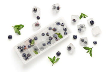 Ice tray with fresh blueberry frozen in ice on white background