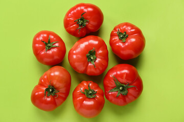 Fresh tomatoes on green background