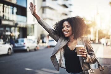 Woman, travel and hands in city for taxi, lift or street transportation with coffee outdoors. Happy female person waving hand and waiting for transport, ride or pickup on road sidewalk in urban town