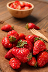 Bowl with fresh strawberries on wooden background