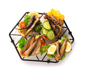 Grid of tasty sandwiches with canned smoked sprats on white background