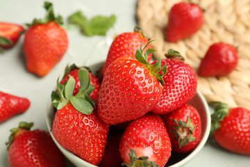Bowl of fresh strawberries on grey background