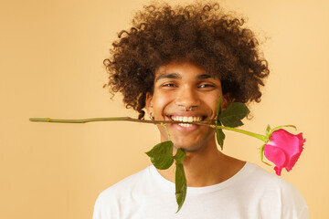 Happy romantic man with rose in mouth for valentine day