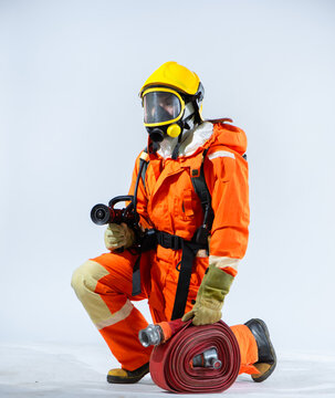 On the pristine white background, a firefighter wearing a helmet and gloves kneels with purpose their grip on the fire hose showcasing their readiness to confront fires head on.