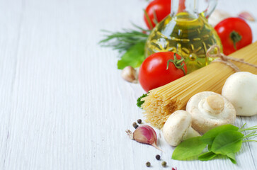 Pasta spaghetti, cheese, vegetables and spices on a white wooden table