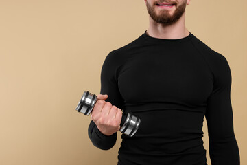 Fototapeta na wymiar Sportsman exercising with dumbbell on brown background, closeup. Space for text