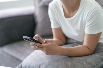 Woman hand using smartphone for checking social media or  woman reading ebook on screen.